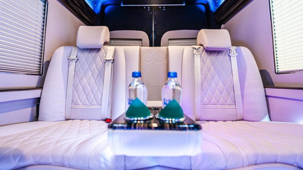 Quilted leather seats with water bottles in a Mercedes Sprinter