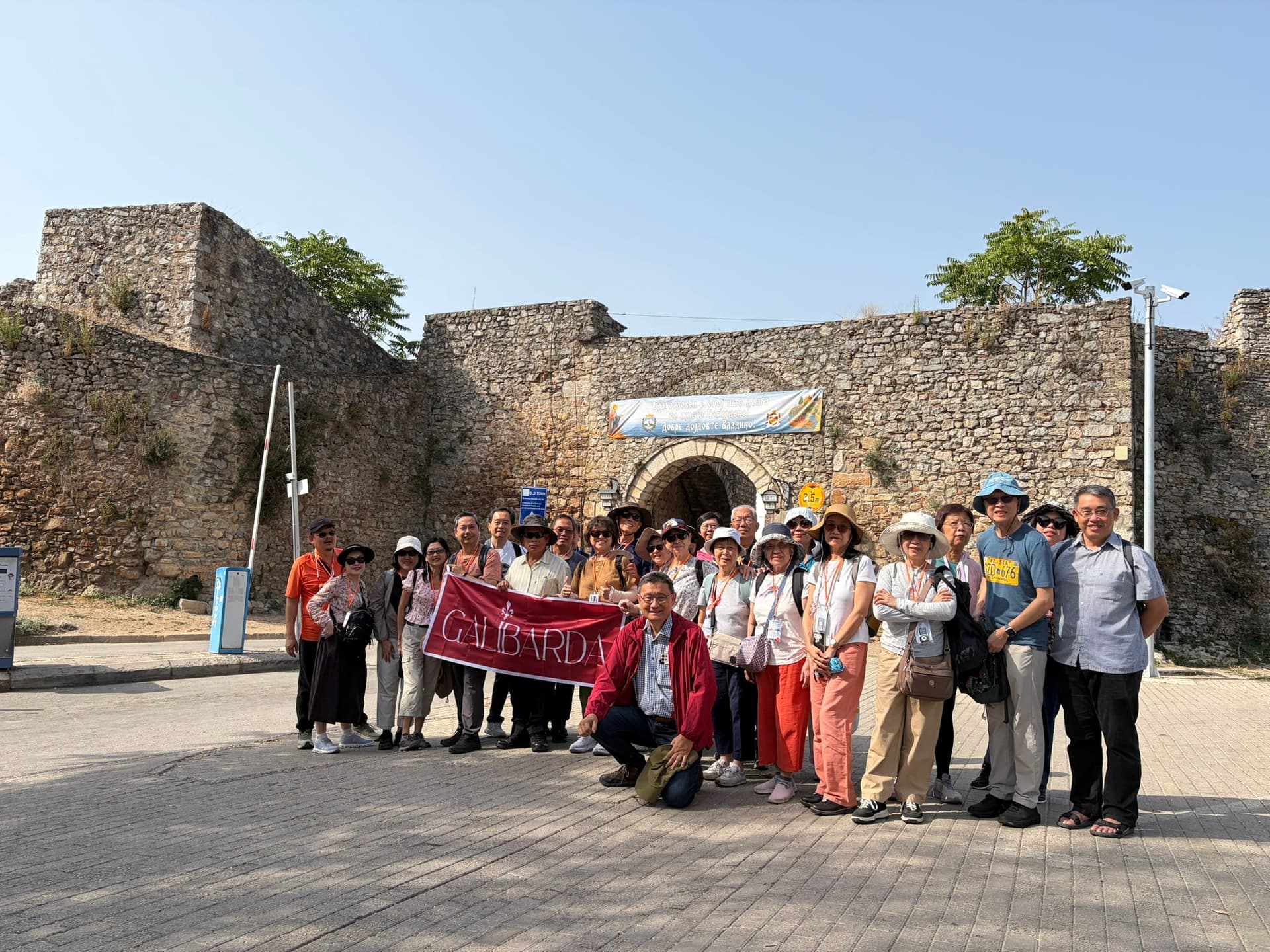 Galibarda group photograph with their guide outside a historic fortress